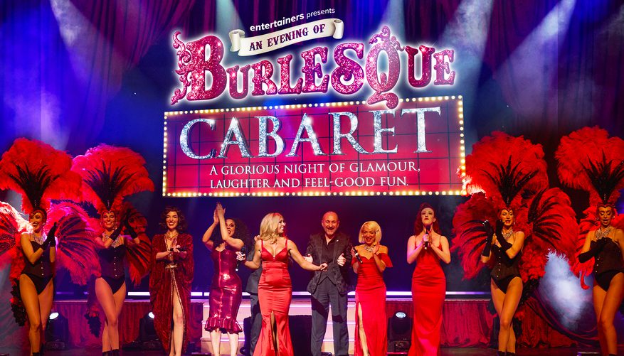 The cast of An Evening of Burlesque Cabaret on stage with show logo/title above them.