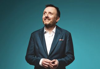 Chris McCausland looking to the left of the frame.