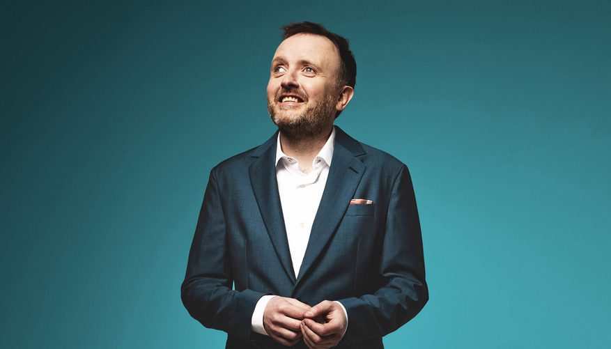 Chris McCausland looking to the left of the frame.