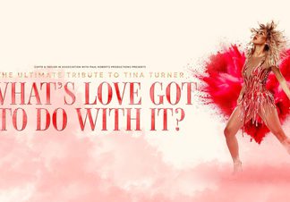 Woman wearing a red dress and heals in front of a red paint explosion in the shape of a heart.