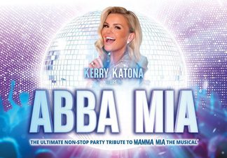 Mid shot of a woman with blonde hair in front of a glitter ball.